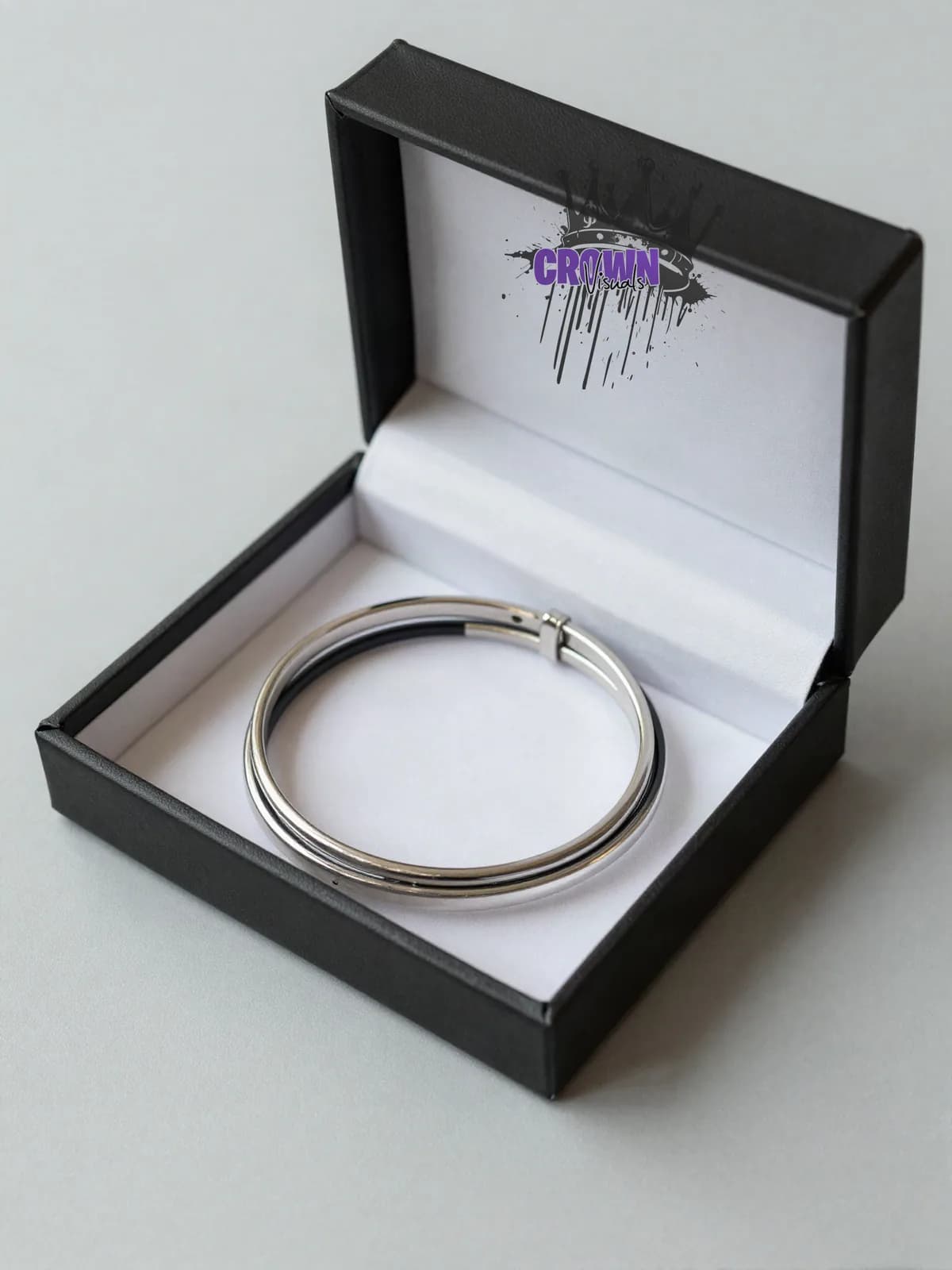 Zwei Edelstahl-Armreifen in einer schwarzen Box mit Logo im Deckel